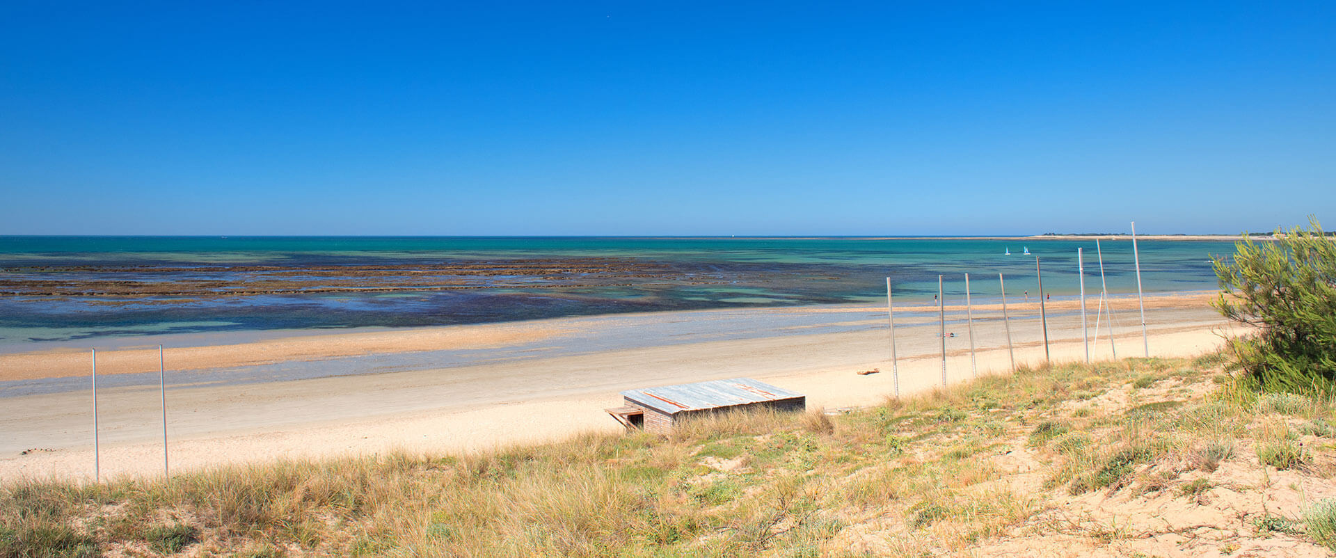 Bandeau Plage Ile de Ré avec mats de bateau et toit cabane